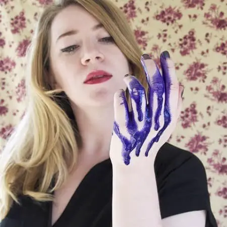 Woman Holding Purple Shampoo On Hand